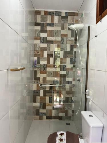 a bathroom with a glass shower with a toilet at Sítio Maravilha em Domigos Martins in Domingos Martins