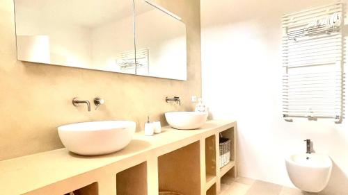 Baño con 2 lavabos y espejo en Trulli di Pone, en Cozzana
