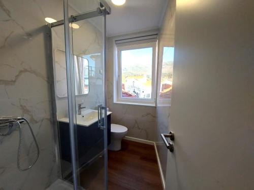 a bathroom with a shower and a sink and a window at Ritta´s House - Covilhã in Covilhã