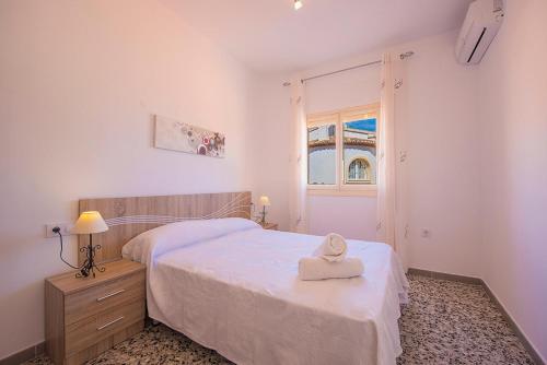 Un dormitorio con una cama con una toalla. en Villa Cronos - PlusHolidays en Calpe
