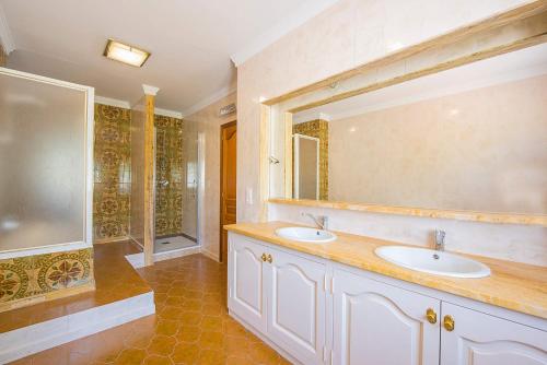 a bathroom with two sinks and a large mirror at Villa Cronos - PlusHolidays in Calpe