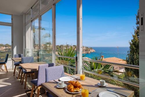 a dining room with a view of the ocean at Flipflop Cala Mandia in Cala Romàntica