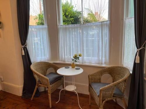una mesa y dos sillas frente a una ventana en Broadstairs Terrace: Central Broadstairs Flat en Broadstairs