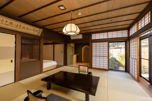 a living room with a table and a bedroom at Hagi No Yado Tomoe in Hagi