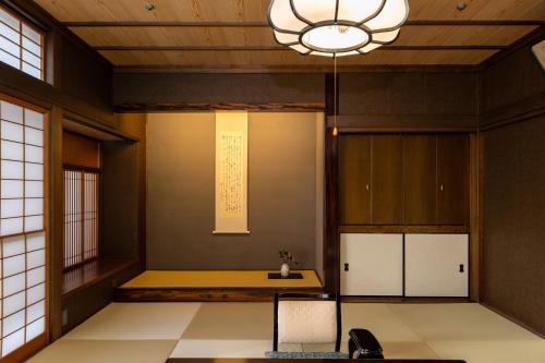 Habitación con mesa y lámpara de araña. en Hagi No Yado Tomoe, en Hagi