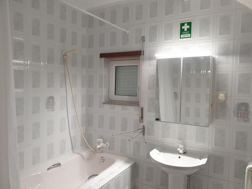 a bathroom with a sink and a tub and a mirror at Cantinho dos Montes in Vila Real