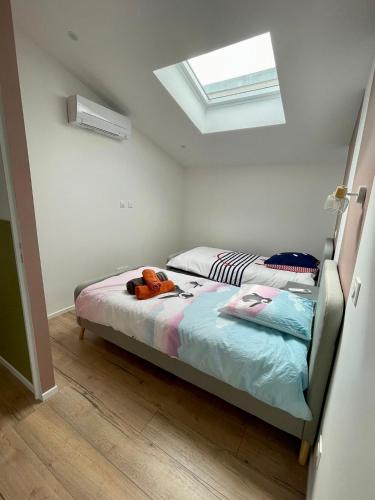 une chambre avec un lit avec un animal en peluche dessus dans l'établissement La Sardinette, à Pessac