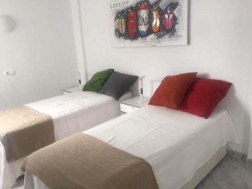 ein Schlafzimmer mit 2 Betten und einem Bild an der Wand in der Unterkunft Near beach 2-Bed Apartment in Centrum Fuengirola in Fuengirola