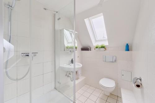 a bathroom with a shower and a toilet and a sink at Ferienwohnung Fährblick Moba-Travel in Travemünde
