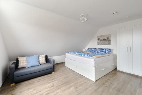 a bedroom with a bed and a couch at Ferienwohnung Fährblick Moba-Travel in Travemünde