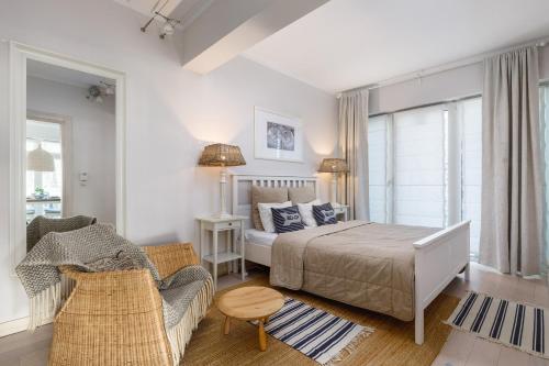 a bedroom with a bed and a couch and a chair at Playa Baltis Apartamenty Club di Mare in Międzyzdroje