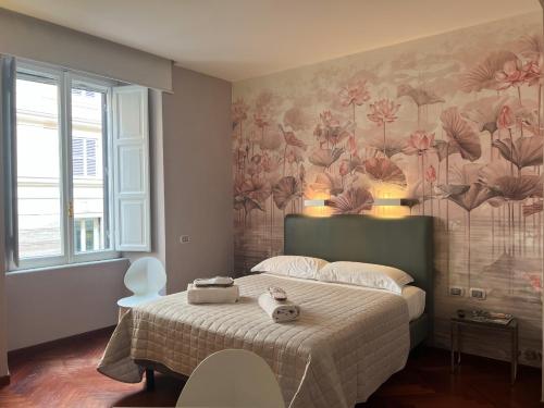 a bedroom with a bed with a floral wallpaper at Dolce Vita Guest House in Rome