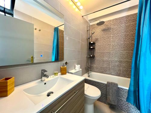 y baño con lavabo, aseo y espejo. en Stunning lovely flat with Pool and strong Wi-Fi, en Arona