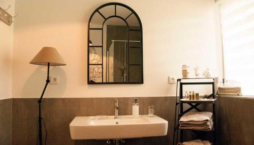 bagno con lavandino e specchio a parete di LaTerrasse, Château Fernand Japy a Beaucourt