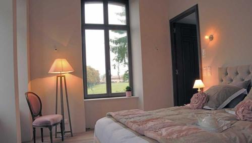 Un dormitorio con una cama grande y una ventana en LaTerrasse, Château Fernand Japy, en Beaucourt