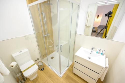 een badkamer met een douche, een toilet en een wastafel bij Hospedería La casa del Alarife in Úbeda