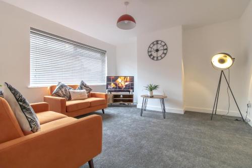 a living room with two couches and a fireplace at Skipton Lodge in Billingham