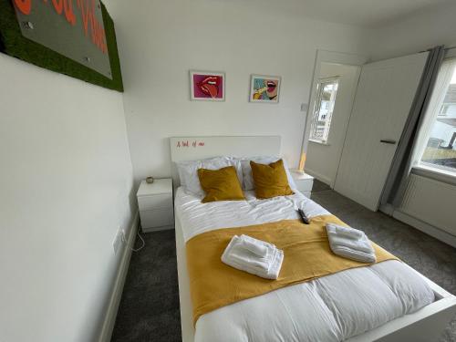 a bedroom with a large bed with yellow pillows at Casa North Coast in Portrush