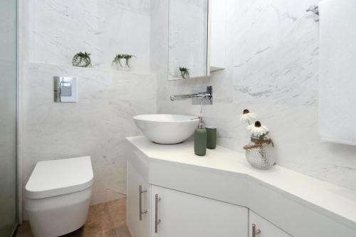 Baño blanco con lavabo y aseo en Apartment Josephine - Beachfront, en Protaras