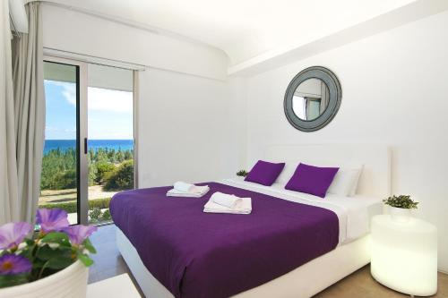 Un dormitorio con una cama con sábanas moradas y una ventana en Apartment Josephine - Beachfront, en Protaras