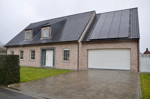 una casa con paneles solares en el techo en Ruime vakantiewoning tot 14pers. met jacuzzi & zwemvijver, en Wingene