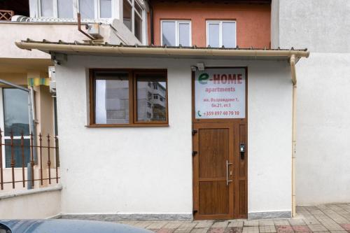 un bâtiment avec une porte munie d'un panneau. dans l'établissement E-home Apartments, à Varna