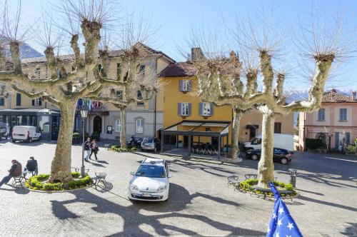 a car parked in a parking lot with trees at Albergo Del Sole in Varenna
