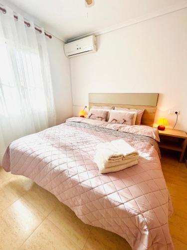 a bedroom with a large bed with two towels on it at Blue Serena - Top floor overlooking the nature in Puerto Marino