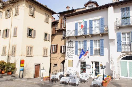 a building with tables and chairs in front of it at Albergo Del Sole in Varenna