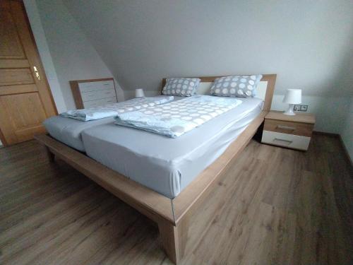 a large bed in a bedroom with a wooden floor at Ferienhaus Eugenie in Sulzfeld (im Grabfeld)