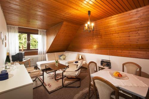 uma sala de estar com paredes e mesas e cadeiras de madeira em Ferienwohnungen Casa Ri(e)sig em Leiwen