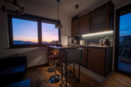 a kitchen with a bar with a view of the mountains at BlackWood Apartment Zlatibor in Zlatibor