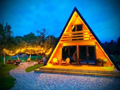 a small wooden house with lights on it at CASA MAYA Câmpulung in Câmpulung