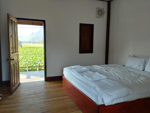 a bedroom with a bed and a view of a vineyard at Konglor Khamchalern Guesthouse and Restaurant in Ban O