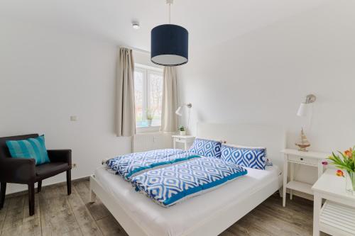 a bedroom with a bed with blue and white pillows at Ferienwohnung Bootsteg Moba-Travel in Priwall