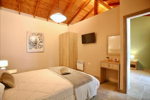 Dormitorio con cama, escritorio y TV en GK Mediterranean Village - Airport Free Shuttle, en Markopoulo