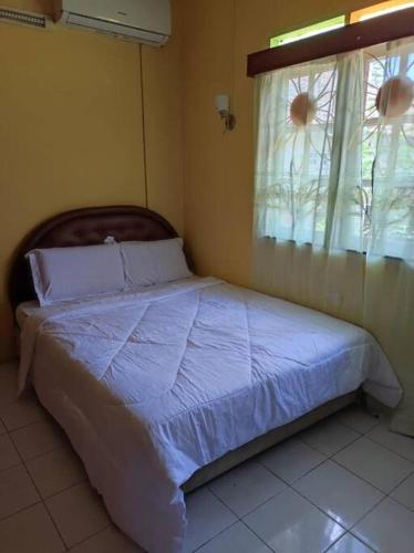 een bed in een slaapkamer met een raam bij Villa Sayang Humairah @ Venice of Perak Intan 2 in Lumut