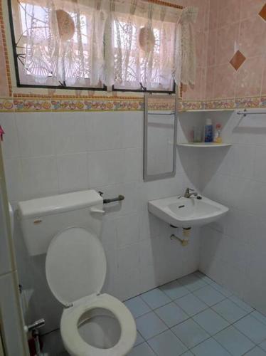 a small bathroom with a toilet and a sink at Villa Sayang Humairah @ Venice of Perak Intan 2 in Lumut