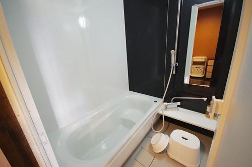 uma casa de banho com banheira e WC em リゾートイン青の洞窟 em Ishigaki