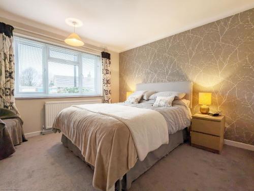 a bedroom with a large bed and a window at Cissa in Chichester