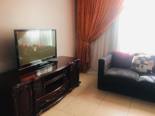 a living room with a couch and a flat screen tv at At Rest Place in Empangeni