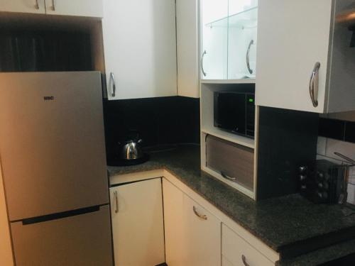 a kitchen with a refrigerator and a microwave at At Rest Place in Empangeni