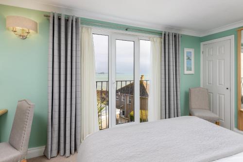 a bedroom with a bed and a large window at Hotel Penzance in Penzance