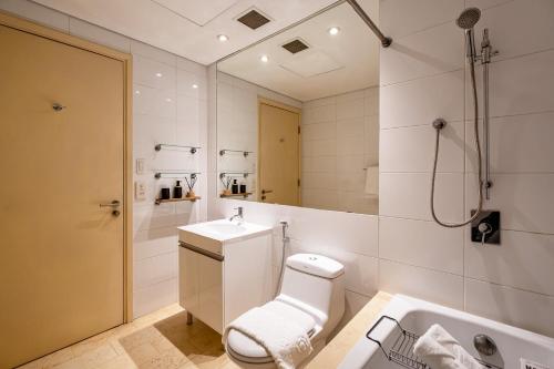 a bathroom with a toilet and a sink and a tub at Luxury Apartments with Rooftop Pool & Gym - Avalon in Ho Chi Minh City