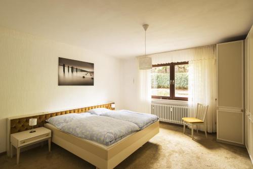 um quarto com uma cama grande e uma janela em Ferienwohnungen Casa Ri(e)sig em Leiwen