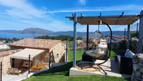 a swing in a yard with a house at Casa mirador Tía Amalia in San Mamede de Carnota