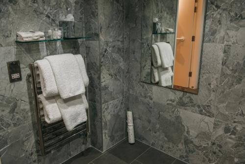 a bathroom with gray marble walls and white towels at The Dean Court in York
