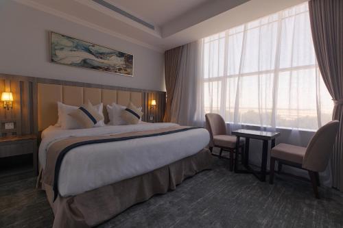 a hotel room with a large bed and a window at فندق نارس بلس البساتين - Nars Plus Hotel in Jeddah