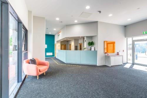 an office lobby with an orange chair and a counter at Ensuite Bedrooms with Shared Kitchen and Studios at Marshall Court in Newcastle in Newcastle upon Tyne