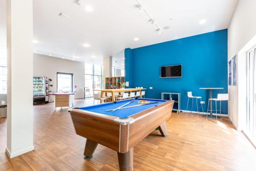 a pool table in a room with a blue wall at Ensuite Bedrooms with Shared Kitchen and Studios at Marshall Court in Newcastle in Newcastle upon Tyne